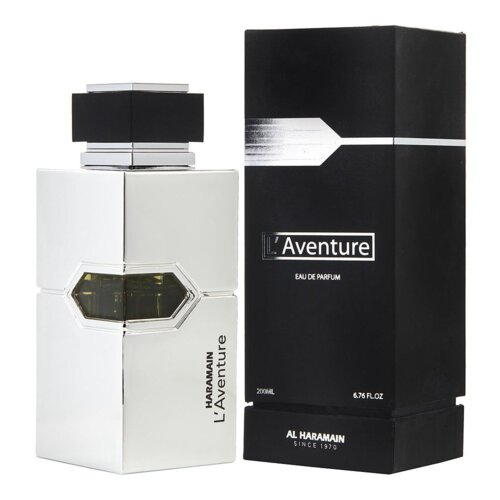 Na zdjęciu widoczna jest srebrna butelka perfum o geometrycznym kształcie z napisem "HARAMAIN L'Aventure" oraz czarne pudełko z białym napisem "L'Aventure EAU DE PARFUM". Na pudełku znajduje się również tekst "200ML 6.76 FL.OZ" oraz "AL HARAMAIN SINCE 1970".