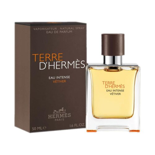 Na zdjęciu widoczna jest butelka perfum oraz pudełko z napisem "TERRE D'HERMÈS EAU INTENSE VÉTIVER". Na pudełku znajduje się także logo "HERMÈS PARIS" oraz oznaczenie pojemności "50 ML e 1.6 FL.OZ".