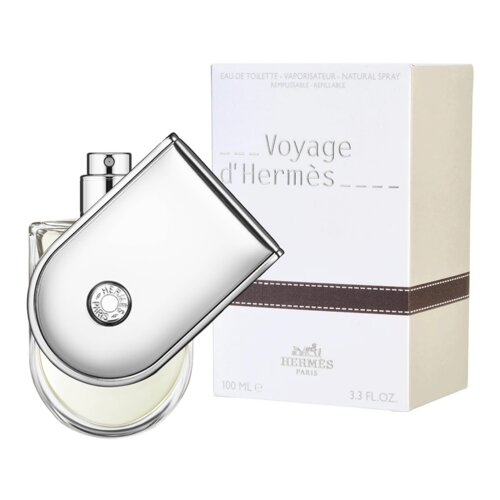 Flakon perfum o nowoczesnym, metalicznym designie znajduje się obok białego pudełka z napisem "Voyage d'Hermès" oraz logo "Hermès Paris". Na pudełku widnieje również tekst "Eau de Toilette - Vaporisateur - Natural Spray" oraz oznaczenie pojemności "100 ML e 3.3 FL.OZ.".