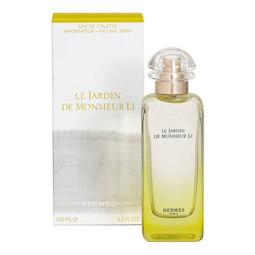 Flakon perfum o pojemności 100 ml z przezroczystym korkiem, obok którego znajduje się pudełko z napisem "LE JARDIN DE MONSIEUR LI". Na pudełku widnieje również tekst "EAU DE TOILETTE VAPORISATEUR - NATURAL SPRAY" oraz "HERMES PARIS 100 ML e 3.3 FL.OZ.".