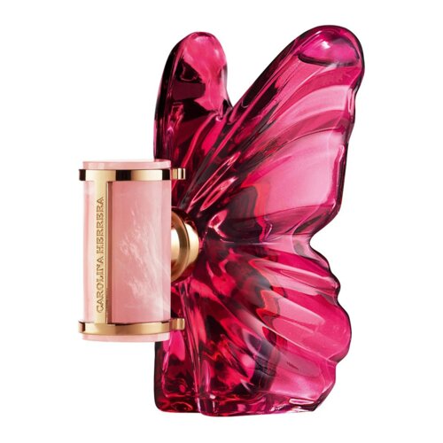Różowy flakon perfum w kształcie motyla z przezroczystymi skrzydłami, z boku widoczny jest złoty element z napisem "CAROLINA HERRERA".