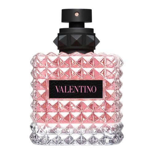 Kwadratowy flakon perfum o różowym zabarwieniu, z wypukłym wzorem przypominającym piramidy, posiada czarny atomizer i etykietę z napisem "VALENTINO".