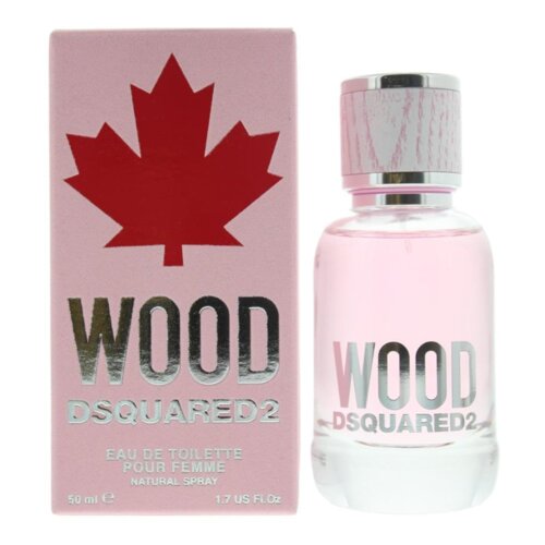 Na zdjęciu znajduje się różowe opakowanie perfum z czerwonym liściem klonu oraz napisem "WOOD DSQUARED2 EAU DE TOILETTE POUR FEMME NATURAL SPRAY 50 ml 1.7 US FL.OZ". Obok opakowania stoi przezroczysta butelka z różowym płynem i srebrnym napisem "WOOD DSQUARED2".