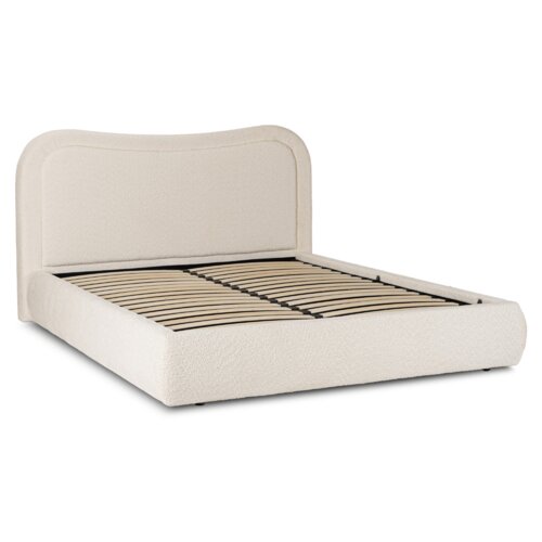 Na zdjęciu znajduje się kremowe, tapicerowane łóżko dwuosobowe o wymiarach 160x200 cm, z widocznym stelażem z listew drewnianych. Zagłówek łóżka ma zaokrąglone krawędzie i jest pokryty materiałem przypominającym baranka.