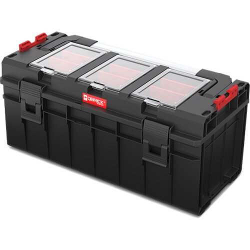 Czarna skrzynka narzędziowa z trzema przezroczystymi pokrywami na górze i czerwonymi elementami, z widocznym logo "QBRICK System". Skrzynka posiada solidne zapięcia i uchwyty po bokach.