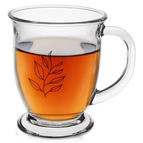 Szklany kubek o pojemności 450 ml z przezroczystym uchwytem, wypełniony napojem o bursztynowym kolorze. Na powierzchni kubka znajduje się czarny wzór przedstawiający gałązkę z liśćmi.