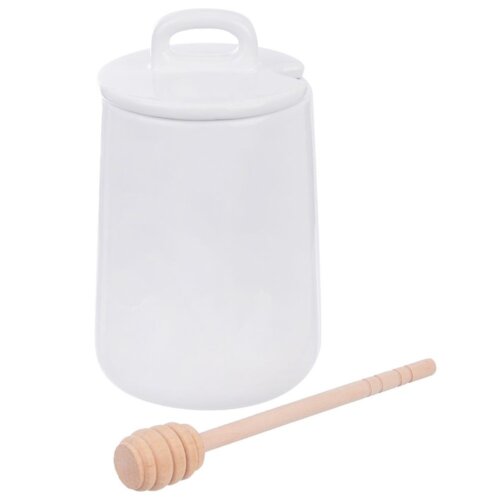 Biały porcelanowy pojemnik na miód z pokrywką i uchwytem, obok którego leży drewniana łyżka do miodu. Produkt ma pojemność 470 ml i jest częścią serii WHITELINE.