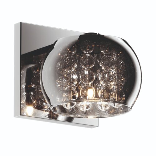 Srebrny kinkiet z przezroczystym kloszem wypełnionym dekoracyjnymi kulkami, zamontowany na prostokątnej podstawie.