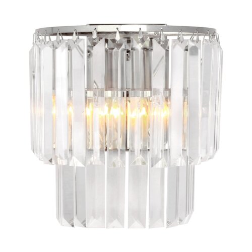 Kinkiet kryształowy w kolorze srebrnym z żarówką E14 o mocy 40W, model AMEDEO Zuma Line, złożony z pionowych, przezroczystych elementów kryształowych, przez które prześwituje światło.